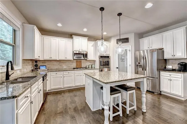 a bedroom with a bed and a lamp on dresser