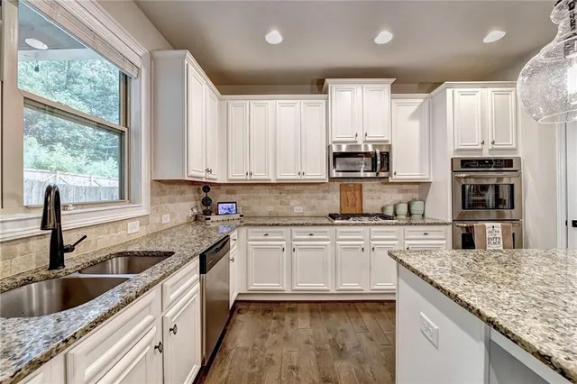 a bathroom with a granite countertop sink a toilet and a mirror