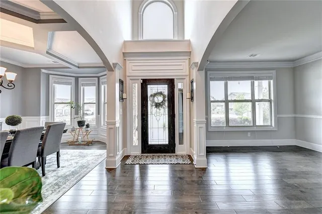a dining room with furniture potted plants and wooden floor