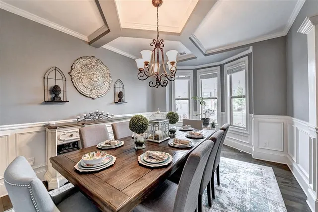 a view of a dining room with furniture a chandelier and wooden floor