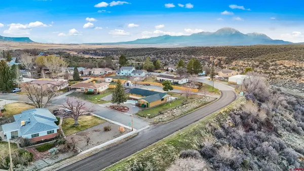 a kitchen with stainless steel appliances kitchen island granite countertop a dining table chairs and a refrigerator