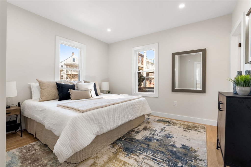 10 Marion Road, Unit 1 Belmont, MA 02478 - Photo 11 of 26 a bedroom with a bed and wooden floor