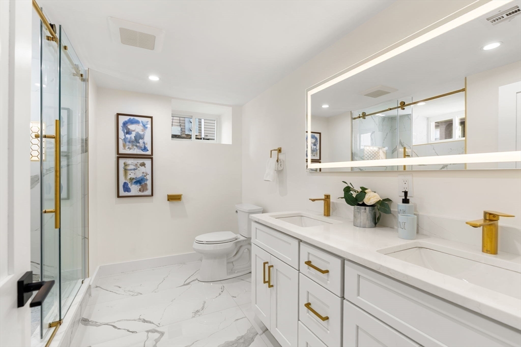 10 Marion Road, Unit 1 Belmont, MA 02478 - Photo 22 of 26 a bathroom with a granite countertop sink mirror vanity and toilet