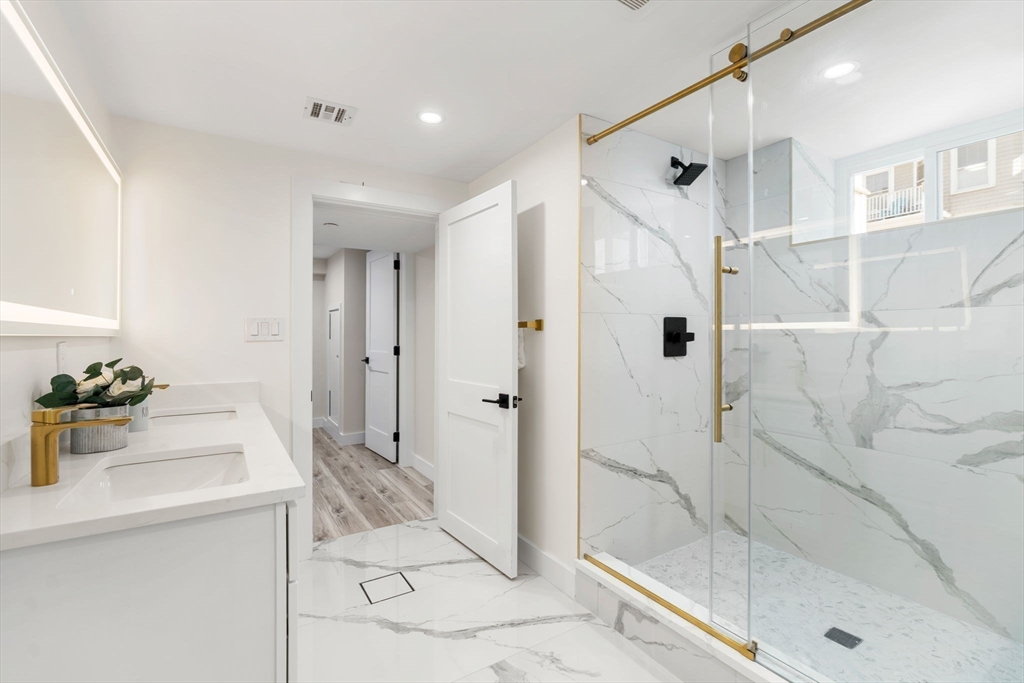 10 Marion Road, Unit 1 Belmont, MA 02478 - Photo 23 of 26 a bathroom with a tub shower sink and mirror