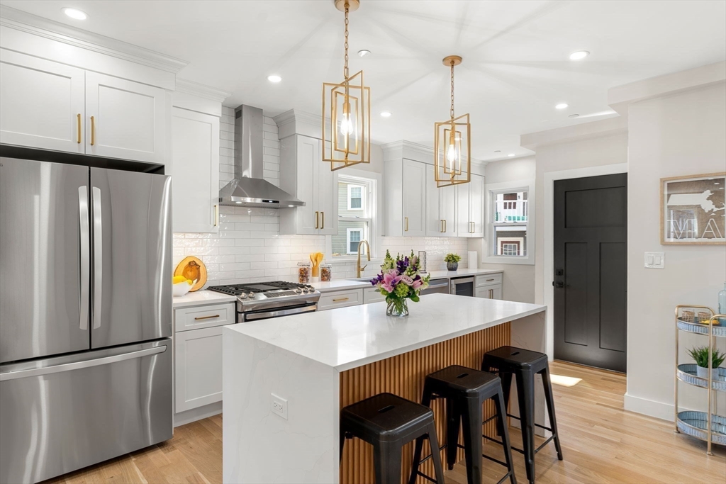 10 Marion Road, Unit 1 Belmont, MA 02478 - Photo 6 of 26 a kitchen with stainless steel appliances a refrigerator a sink a stove a dining table and chairs