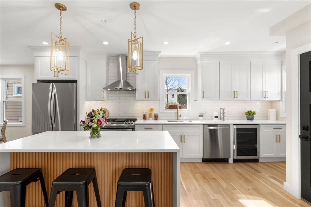 10 Marion Road, Unit 1 Belmont, MA 02478 - Photo 7 of 26 a kitchen with stainless steel appliances a dining table chairs refrigerator and sink