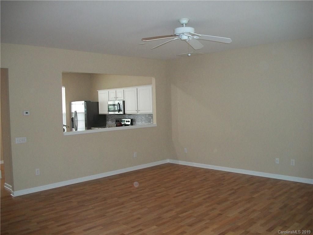 6646 Rothchild Drive Charlotte, NC 28270 - Photo 5 of 23 a view of a kitchen with wooden floor and a ceiling fan