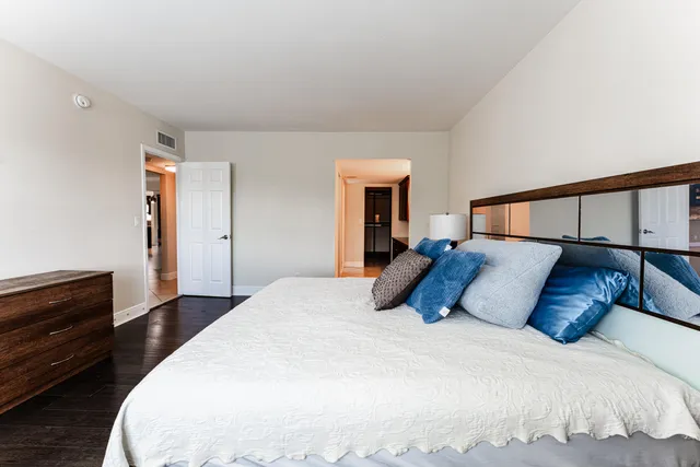 a bedroom with a large bed and a chandelier