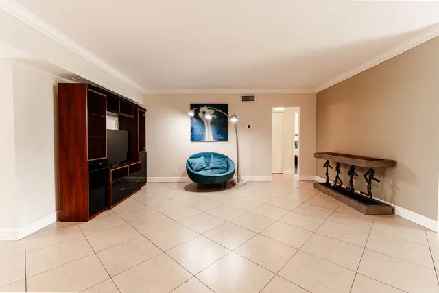a view of an empty room and kitchen