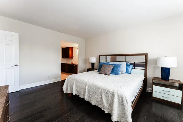 a bedroom with a bed and wooden floor