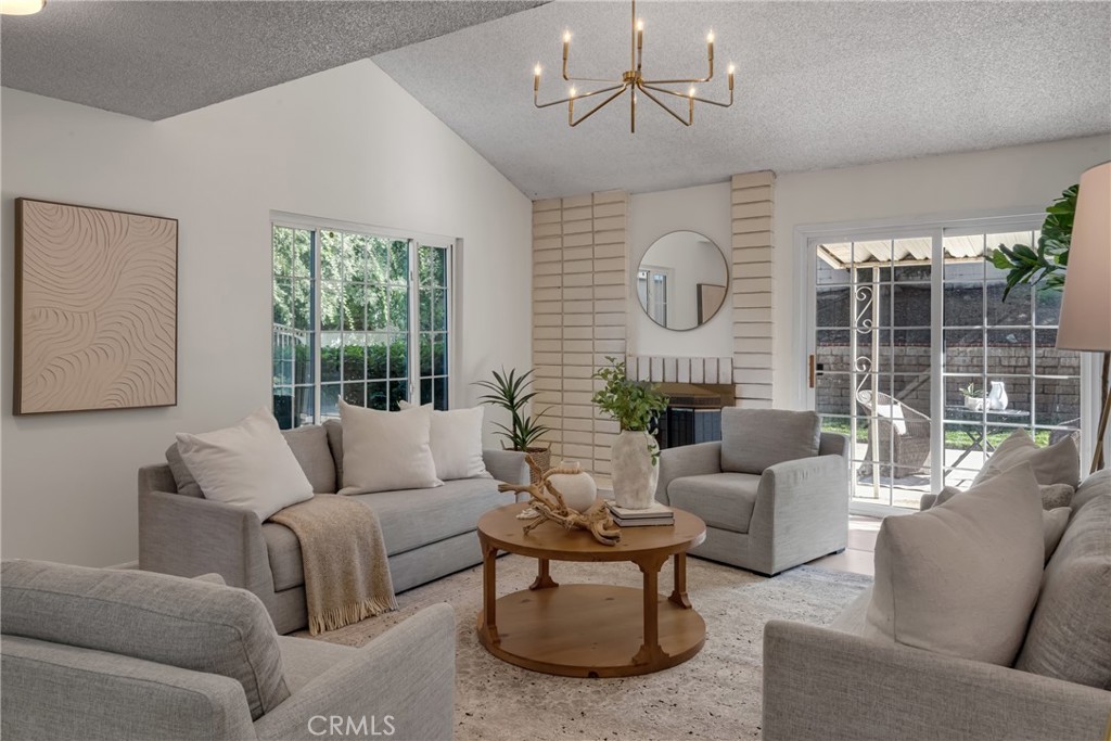 a living room with furniture a chandelier and a large window