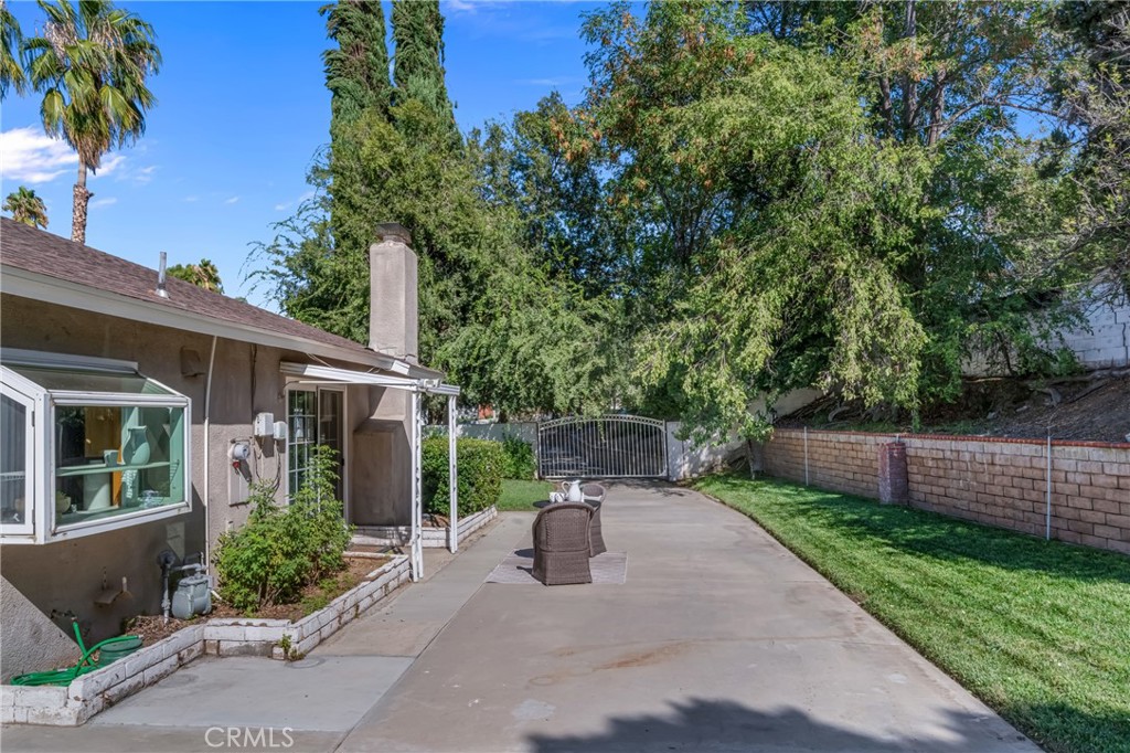 5165 Pearblossom Drive Riverside, CA 92507 - Photo 15 of 75 a view of a patio with table and chairs potted plants and large tree