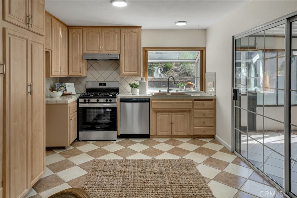 5165 Pearblossom Drive Riverside, CA 92507 - Photo 21 of 75 a kitchen with stainless steel appliances granite countertop a stove a sink and a refrigerator