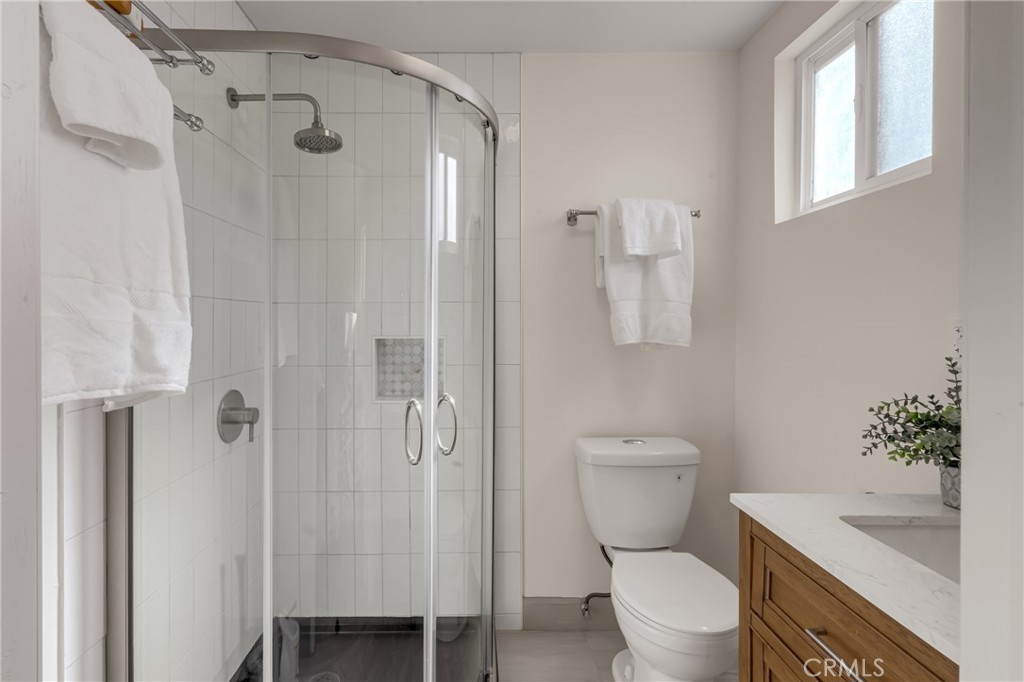 5165 Pearblossom Drive Riverside, CA 92507 - Photo 54 of 75 a bathroom with a granite countertop toilet a sink and a shower