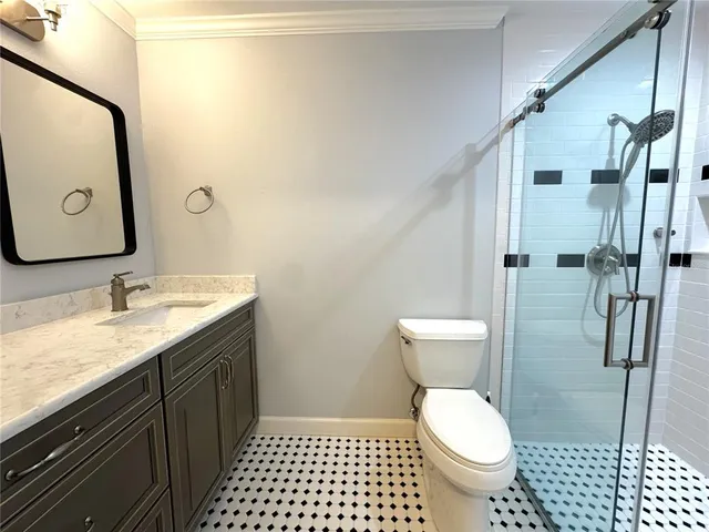 a bathroom with a granite countertop toilet sink and mirror