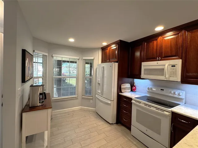 a kitchen with stainless steel appliances granite countertop a refrigerator stove and sink