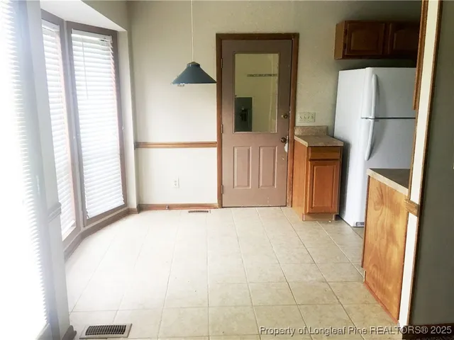 a view of a kitchen with furniture and a refrigerator