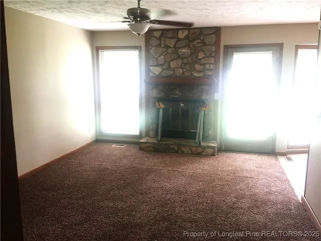 a view of empty room with a fireplace