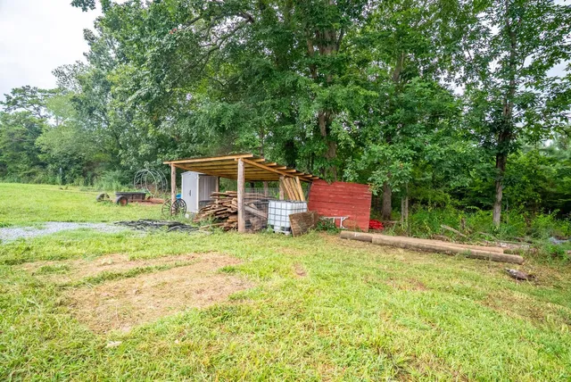 a backyard of a house with barbeque oven table and chairs