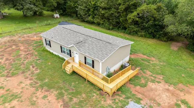 a view of a lush green forest with trees and some houses