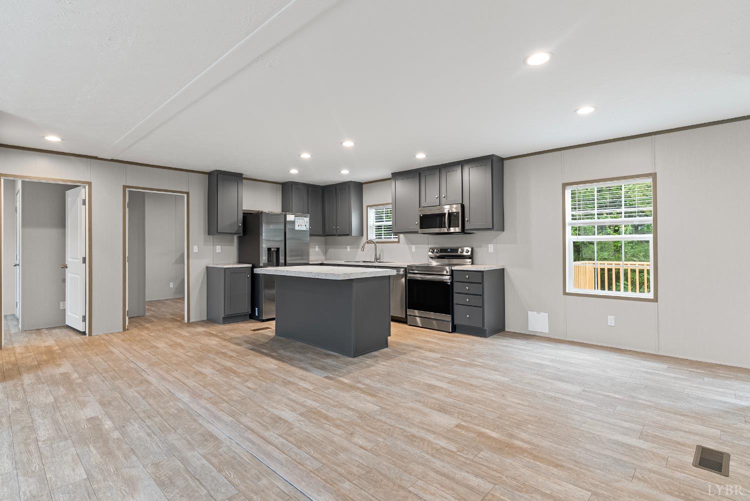 4526 Pigeon Run Road Gladys, VA 24554 - Photo 6 of 54 a large kitchen with stainless steel appliances granite countertop a stove a sink dishwasher a refrigerator and white cabinets with wooden floor