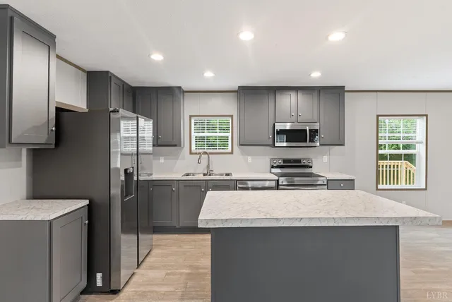 a kitchen with a refrigerator a sink a stove a microwave and wooden cabinets