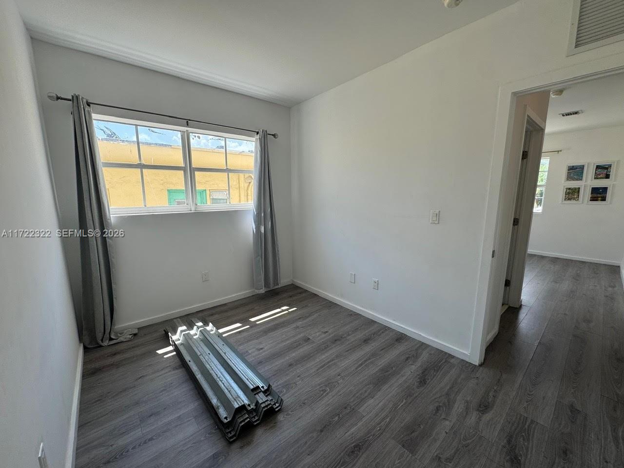 810 7th Street, Unit 207 Miami Beach, FL 33139 - Photo 9 of 16 an empty room with wooden floor and windows