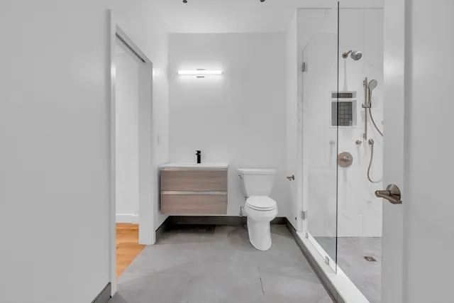 a bathroom with a shower a toilet and a sink