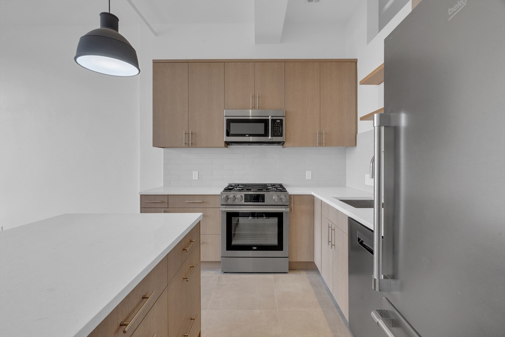 70-72 Northampton Street, Unit 502 Boston, MA 02118 - Photo 5 of 19 a kitchen with granite countertop a stove and a sink