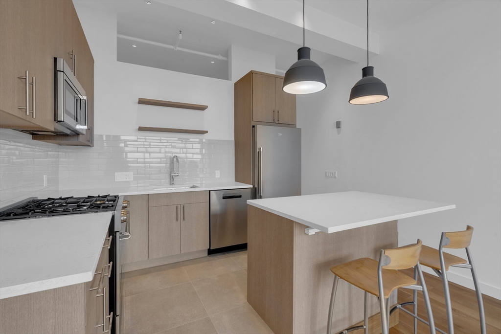 70-72 Northampton Street, Unit 502 Boston, MA 02118 - Photo 6 of 19 a kitchen with a table chairs and white cabinets