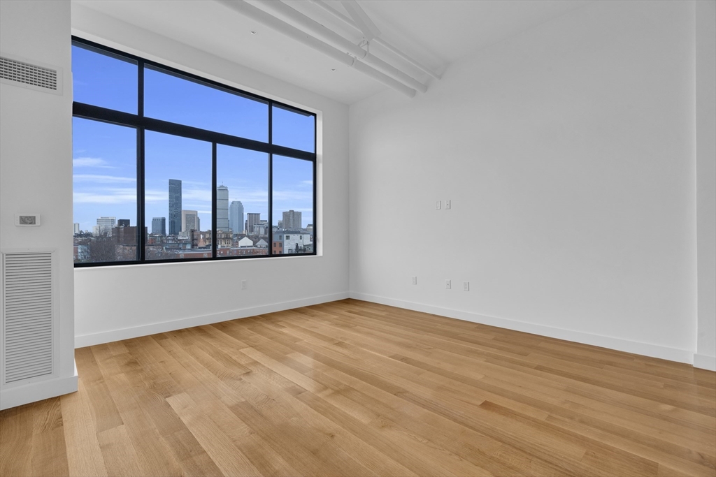 70-72 Northampton Street, Unit 502 Boston, MA 02118 - Photo 10 of 19 an empty room with wooden floor and windows