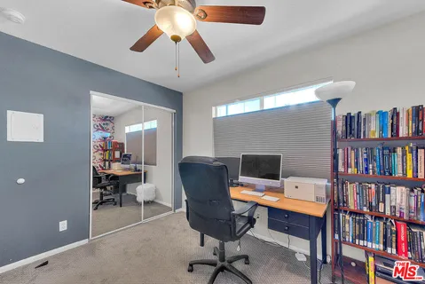 a view of a livingroom with workspace and a window