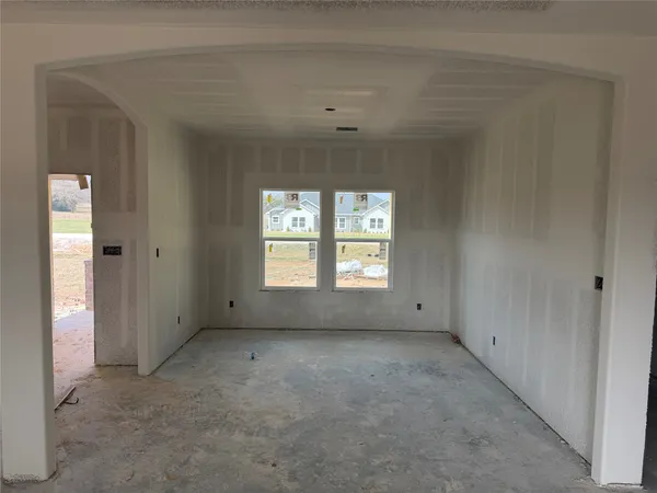 a view of an empty room with a fireplace and a window