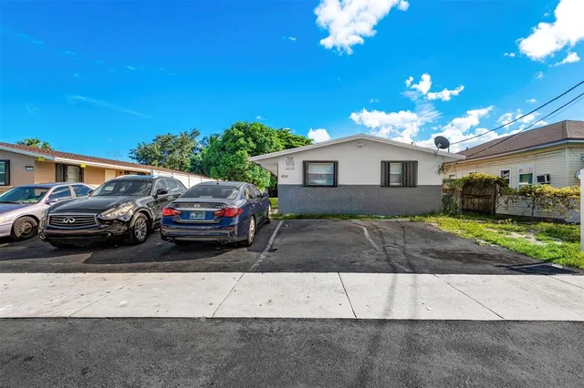 a view of a white house with a yard