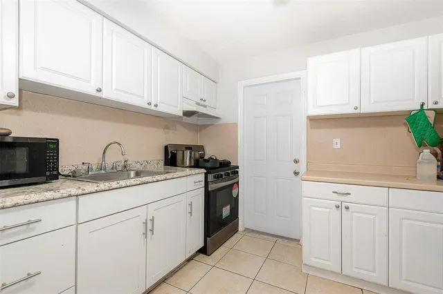 a kitchen with granite countertop white cabinets and white appliances