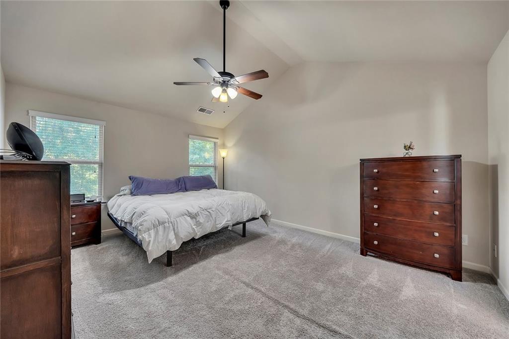 6204 Oakdale Ridge Court Southeast Mableton, GA 30126 - Photo 18 of 48 a spacious bedroom with a bed and a chandelier