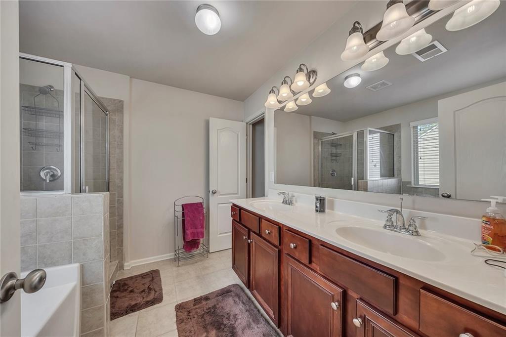 6204 Oakdale Ridge Court Southeast Mableton, GA 30126 - Photo 20 of 48 a spacious bathroom with a double vanity sink mirror and chandelier