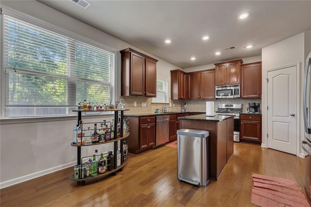 6204 Oakdale Ridge Court Southeast Mableton, GA 30126 - Photo 7 of 48 a kitchen with granite countertop wooden floors stainless steel appliances and sink