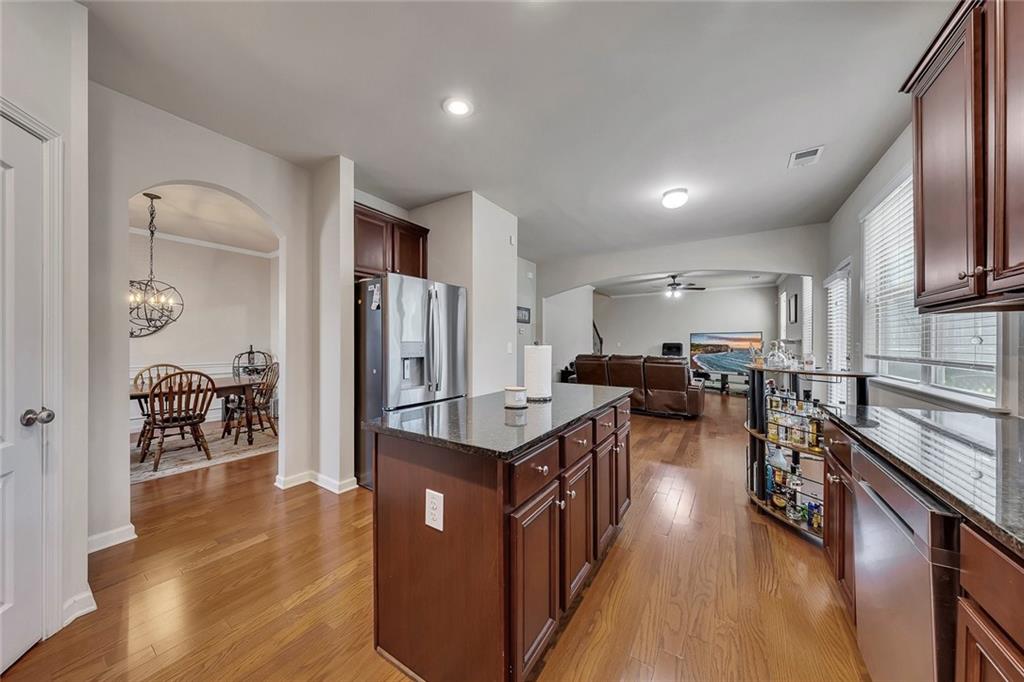 6204 Oakdale Ridge Court Southeast Mableton, GA 30126 - Photo 10 of 48 a open kitchen with stainless steel appliances granite countertop a stove top oven a refrigerator a sink and dishwasher with wooden floor