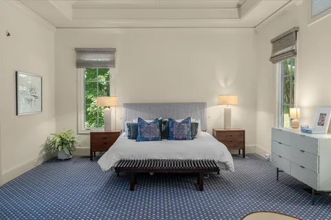 a bedroom with a bed chandelier and a window