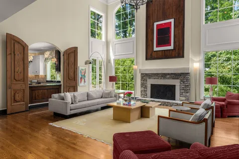 a living room with fireplace furniture and a large window
