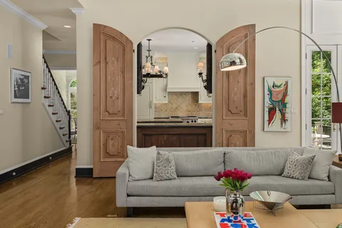 a dining table with a large window and white kitchen