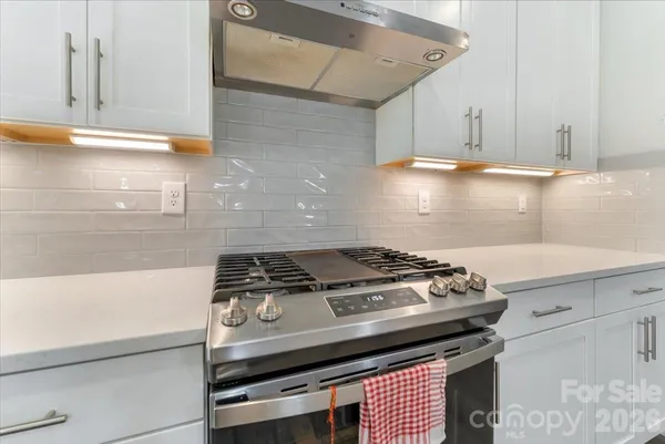 a stove top oven sitting inside of a kitchen