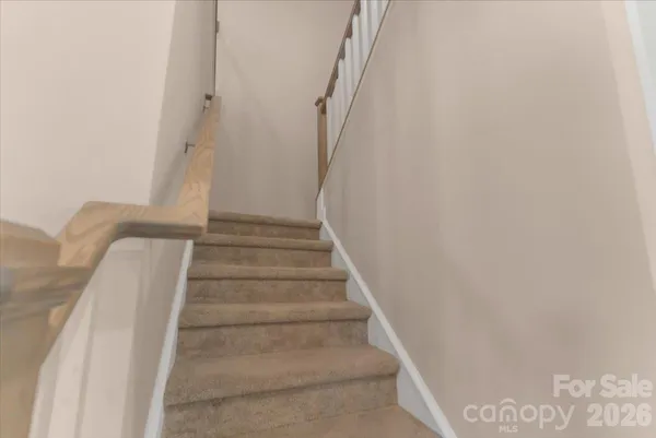 a view of staircase with white walls and white door