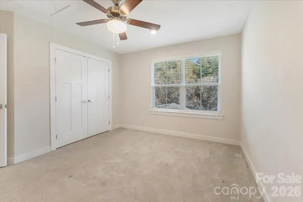 an empty room with a window and a fan
