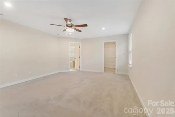 an empty room with a ceiling fan and a window
