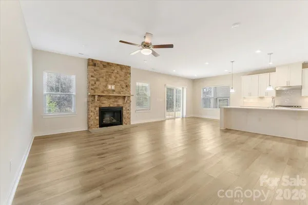a view of a livingroom with furniture a fireplace and wooden floor