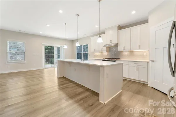 an open kitchen with kitchen island white cabinets and stainless steel appliances