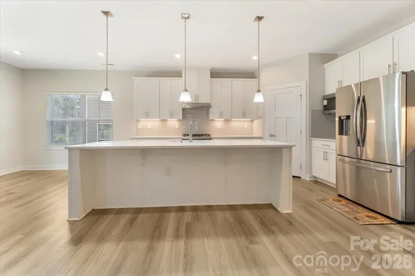a kitchen with kitchen island a counter top space wooden floor and appliances