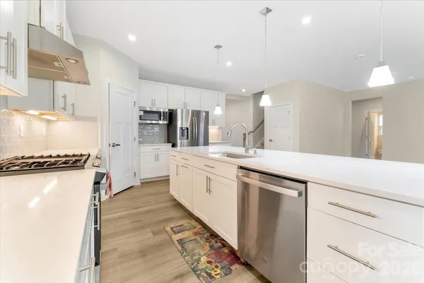 a large kitchen with a lot of counter space and a wooden floor